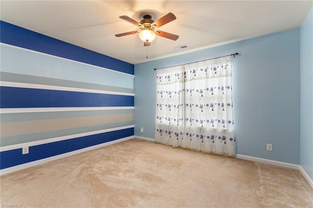 spare room with a ceiling fan, carpet, visible vents, and baseboards