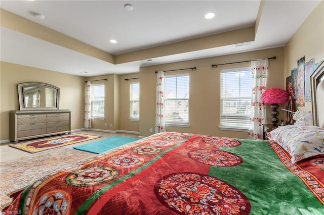 bedroom with a tray ceiling, recessed lighting, and baseboards