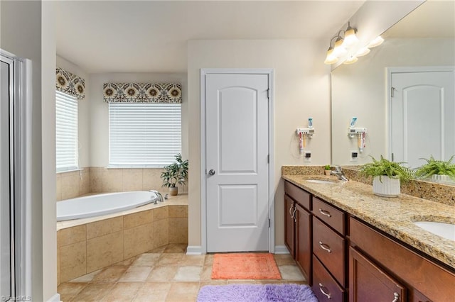 full bathroom with a garden tub, double vanity, and a sink