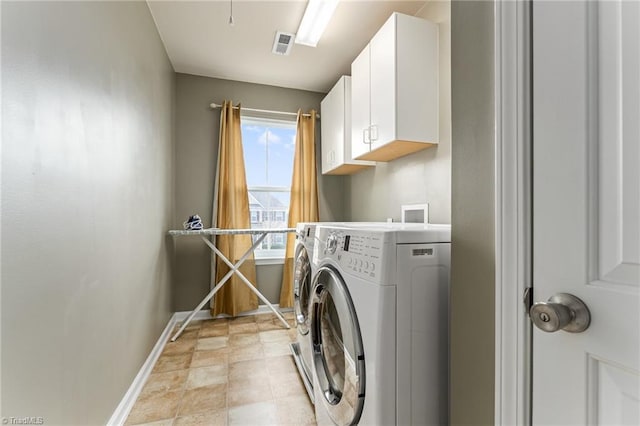 washroom with cabinet space, baseboards, visible vents, and separate washer and dryer