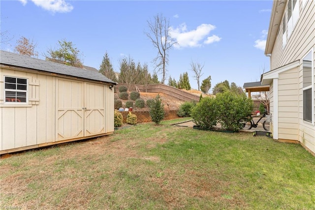 view of yard featuring an outdoor structure, fence, and a storage unit