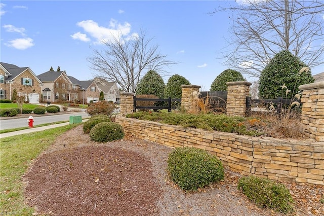 community / neighborhood sign featuring a residential view and fence