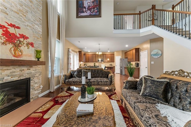 living room with baseboards, wood finished floors, stairs, a high ceiling, and a fireplace