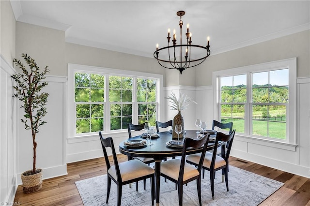 dining area with a notable chandelier, wood-type flooring, and a wealth of natural light