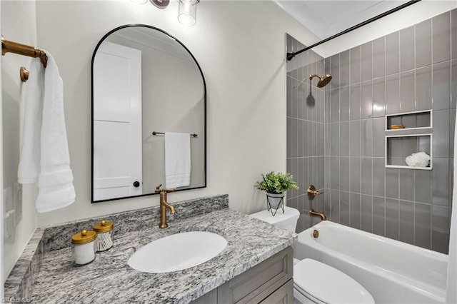 full bathroom with vanity, tiled shower / bath combo, and toilet