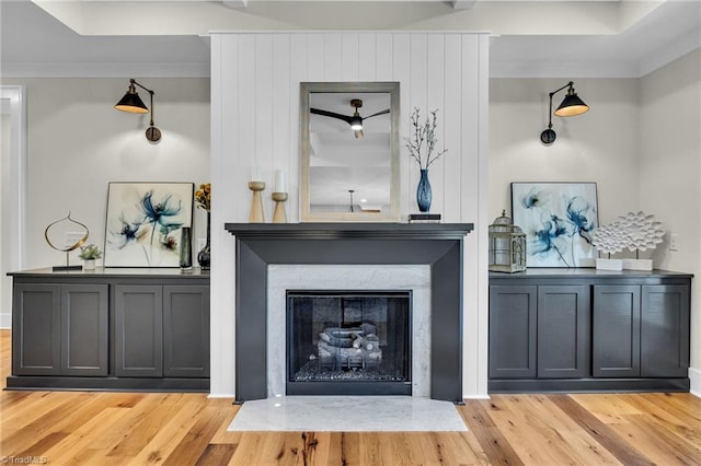 interior details with a high end fireplace, wood-type flooring, and ornamental molding