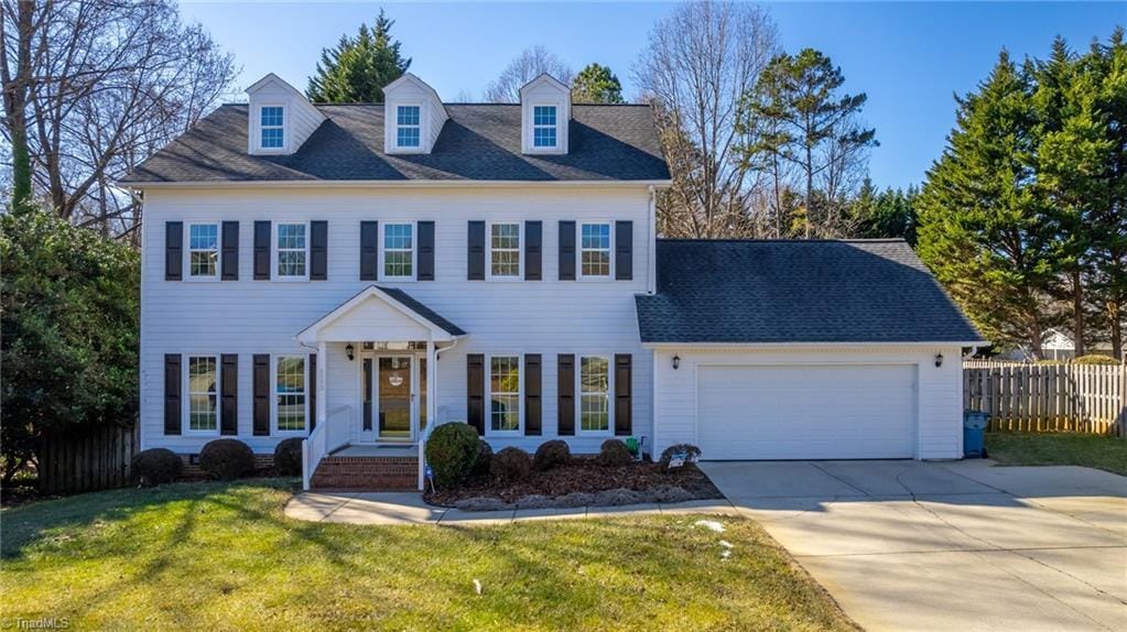 colonial inspired home with a garage and a front yard