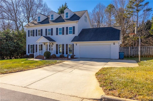 colonial-style house featuring a garage and a front lawn