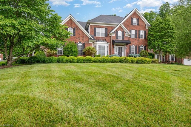 221 Oakmont Park Ct, Kernersville, NC 27284 - colonial house with brick siding and a front yard