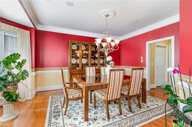 221 Oakmont Park Ct, Kernersville, NC 27284 - dining room with crown molding, a chandelier, light wood-type flooring, and baseboards