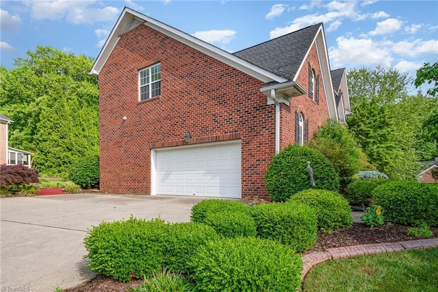 221 Oakmont Park Ct, Kernersville, NC 27284 - view of home's exterior featuring brick siding, concrete driveway, an attached garage, and a shingled roof