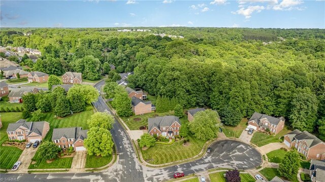221 Oakmont Park Ct, Kernersville, NC 27284 - aerial view of property and surrounding area with a heavily wooded area and nearby suburban area