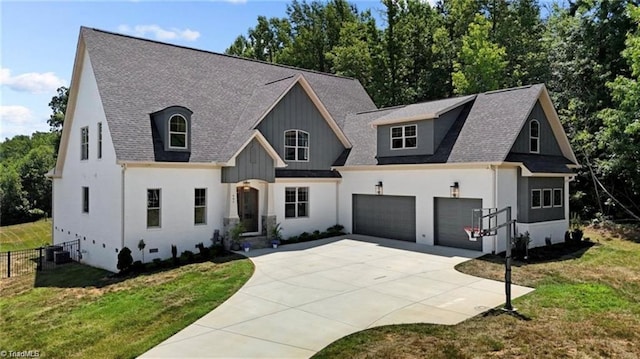 view of front of home featuring central AC unit, a garage, and a front yard