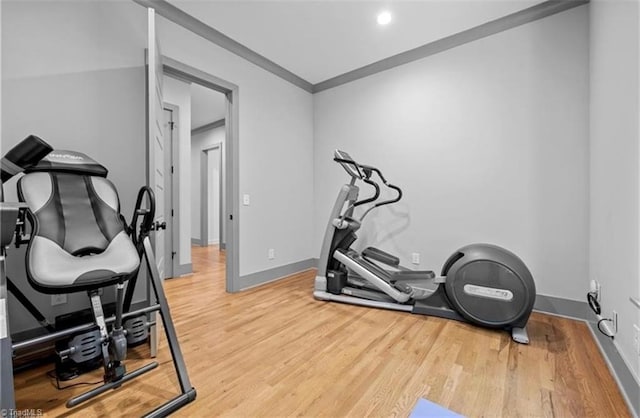 exercise area featuring crown molding and hardwood / wood-style floors