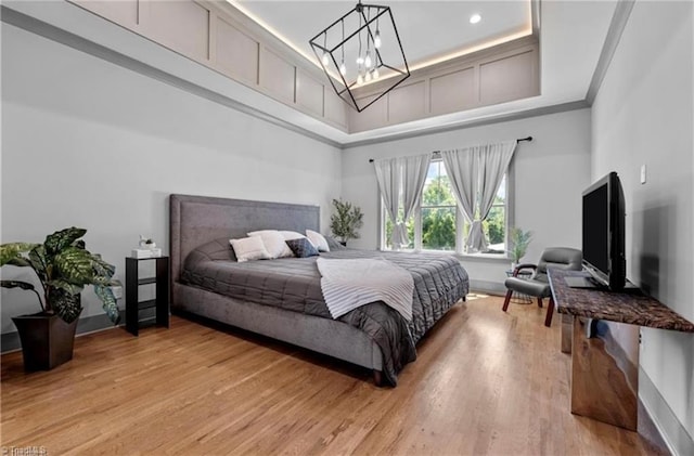 bedroom with ornamental molding, a chandelier, and light wood-type flooring