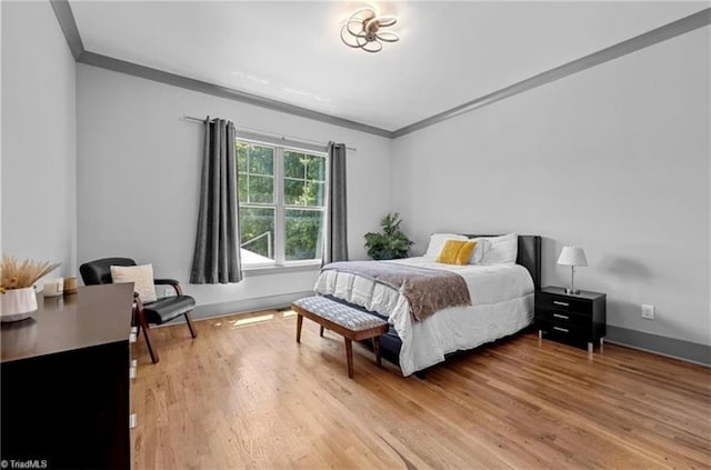 bedroom with ornamental molding and hardwood / wood-style floors