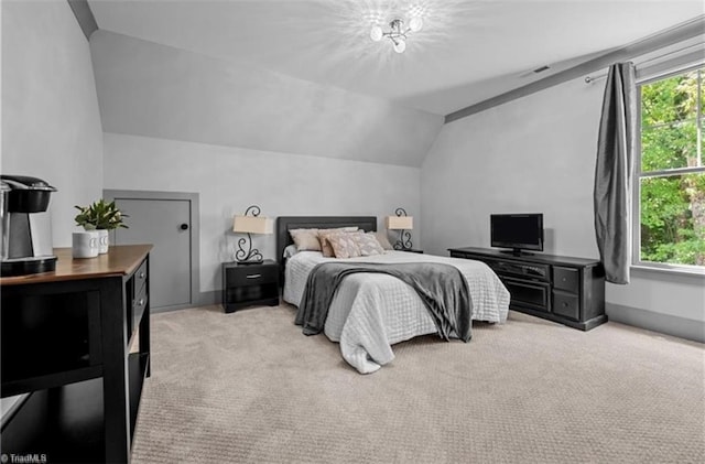 bedroom featuring lofted ceiling, multiple windows, and light carpet