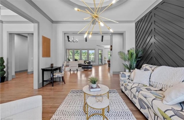 living room with an inviting chandelier, ornamental molding, and hardwood / wood-style flooring