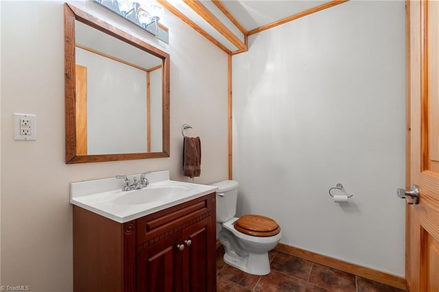 bathroom with vanity, baseboards, and toilet