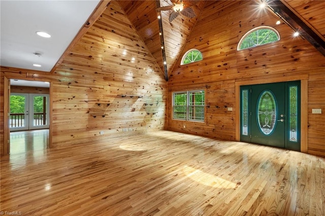 entryway featuring french doors, wood finished floors, wooden walls, and high vaulted ceiling