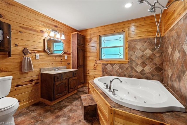 bathroom with vanity, toilet, wooden walls, and a whirlpool tub