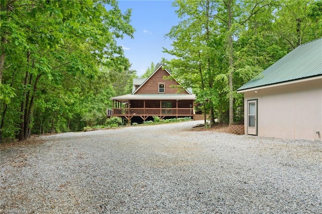 view of front of home featuring driveway, metal roof, and stucco siding
