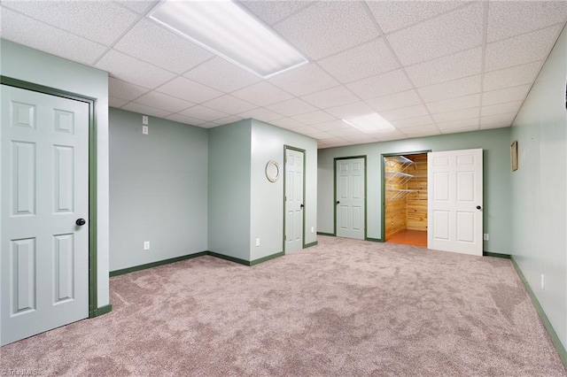 interior space featuring baseboards, carpet flooring, and a paneled ceiling
