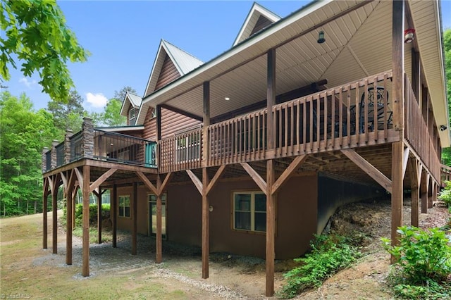back of property featuring a carport, a deck, and log veneer siding