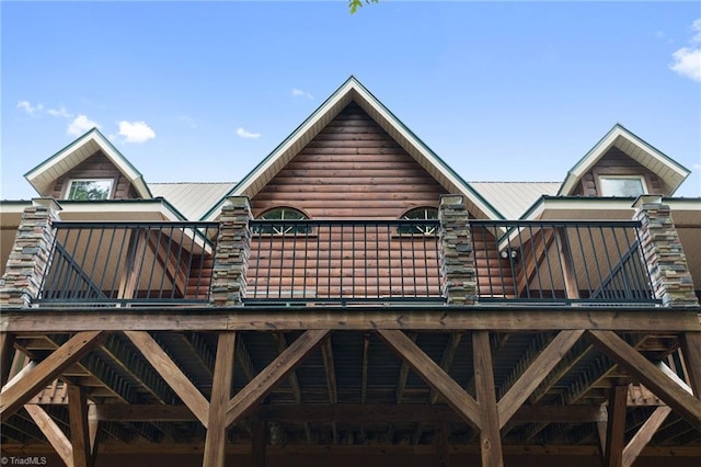 rear view of house featuring metal roof and a wooden deck