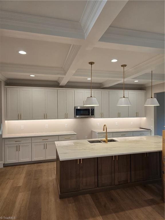3501 Wesley Point Dr, Browns Summit, NC 27214 - kitchen featuring stainless steel microwave, white cabinetry, beam ceiling, dark wood-style floors, and ornamental molding