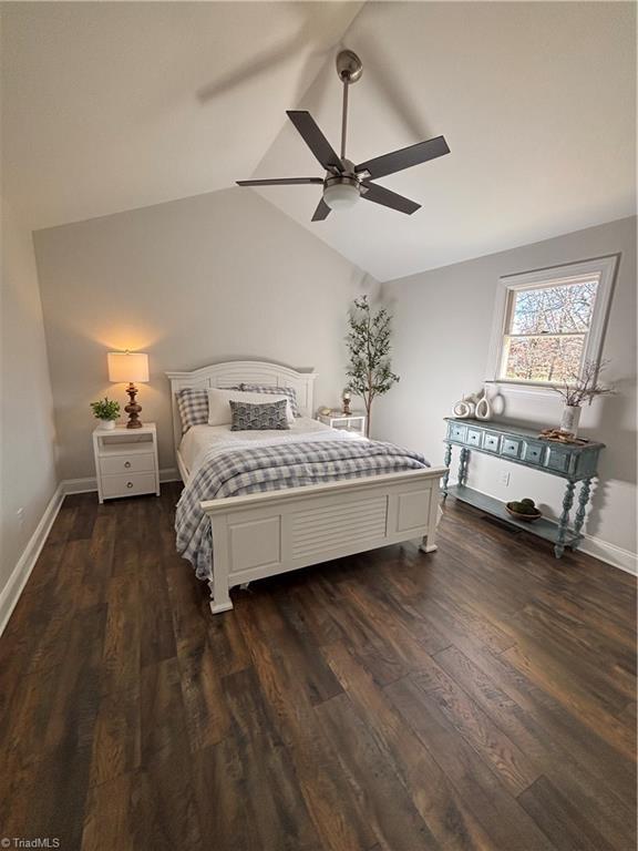 bedroom with vaulted ceiling, dark hardwood / wood-style floors, and ceiling fan