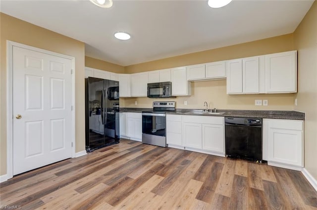 kitchen with white cabinetry, sink, dark wood-type flooring, and black appliances