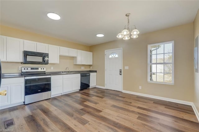 kitchen featuring decorative light fixtures, white cabinetry, dark hardwood / wood-style floors, and black appliances