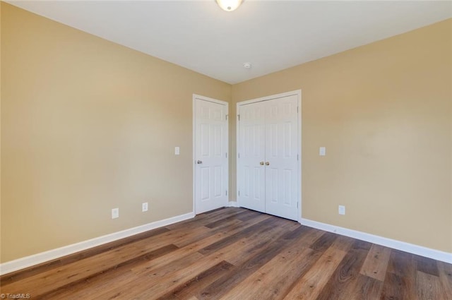 unfurnished bedroom featuring dark hardwood / wood-style floors and a closet