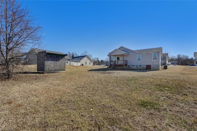 rear view of property with a yard and a storage shed