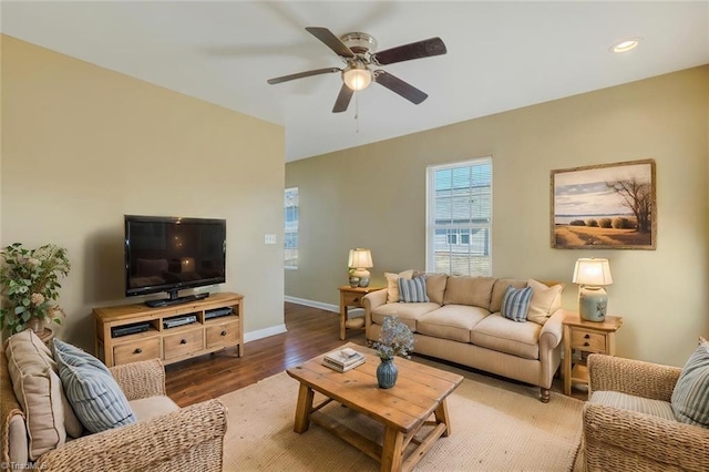 living room featuring dark wood-type flooring and ceiling fan