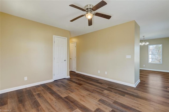 unfurnished room with dark hardwood / wood-style flooring and ceiling fan with notable chandelier