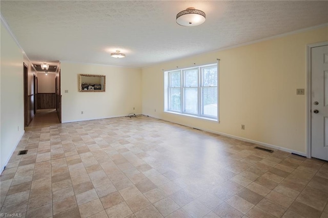 spare room featuring a textured ceiling and crown molding