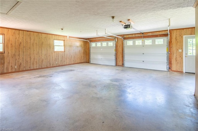 garage with wood walls and a garage door opener