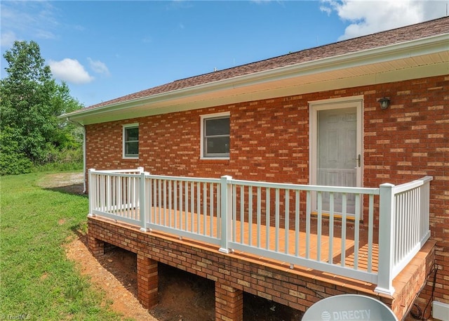 rear view of property with a yard and a deck