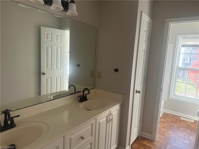 bathroom with vanity, a notable chandelier, and parquet floors