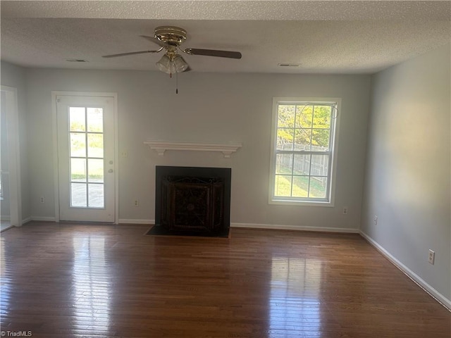 unfurnished living room with a textured ceiling, dark hardwood / wood-style floors, and ceiling fan