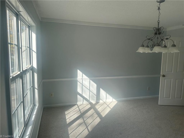 empty room with crown molding, a notable chandelier, and carpet floors