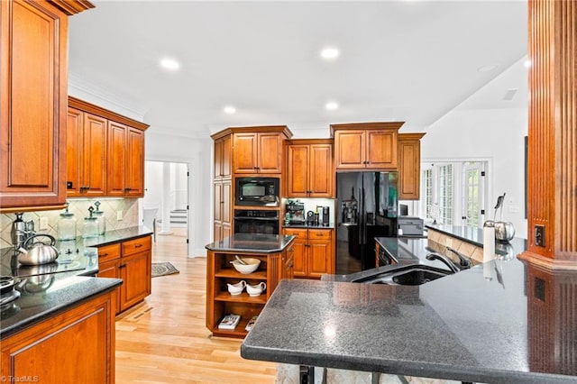 kitchen featuring black appliances, a sink, open shelves, a kitchen island, and brown cabinets