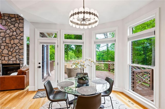 sunroom featuring vaulted ceiling and a chandelier