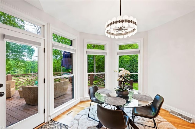 sunroom featuring wood finished floors, baseboards, and a deck