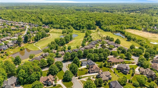 aerial perspective of suburban area with a large body of water, a forest, and a golf course