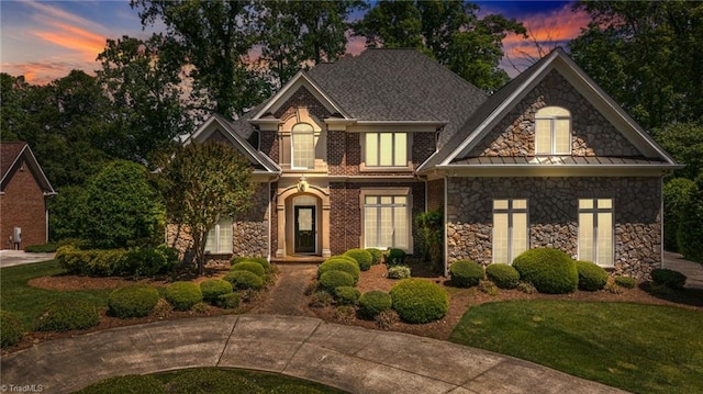 view of front of property featuring stone siding and a standing seam roof