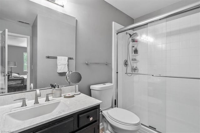 bathroom with walk in shower, vanity, and toilet