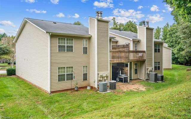 rear view of house with central AC unit and a yard